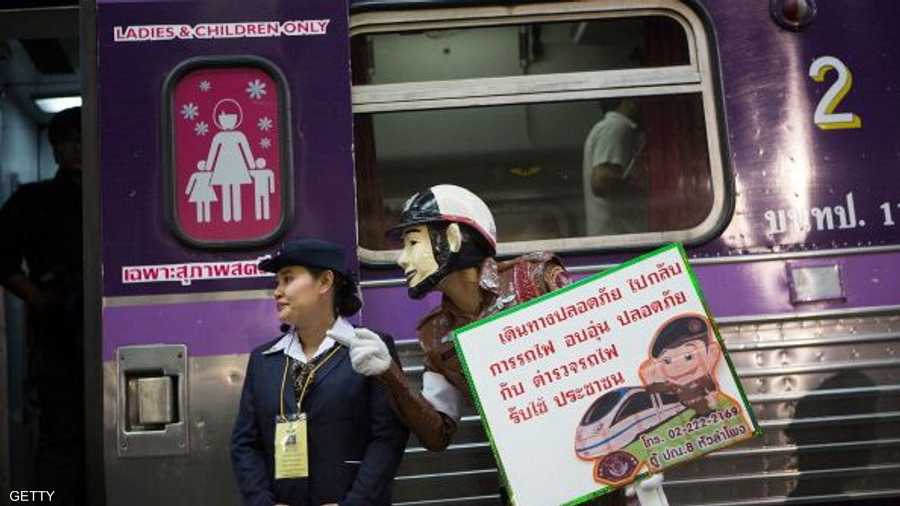 شرطي وشرطية يوجهان الراكبات إلى عربة السيدات