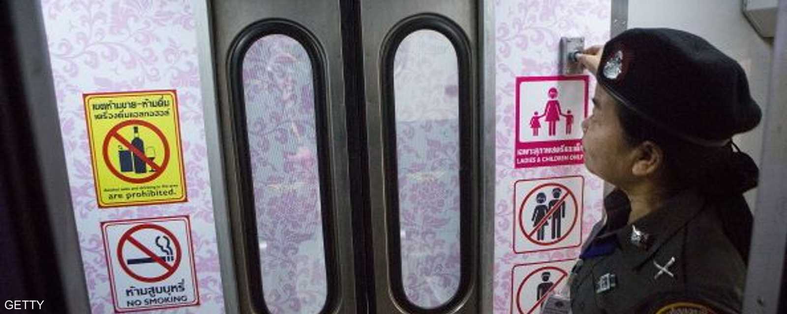 شرطية تفتح الباب لعربة السيدات