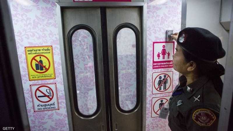 شرطية تفتح الباب لعربة السيدات